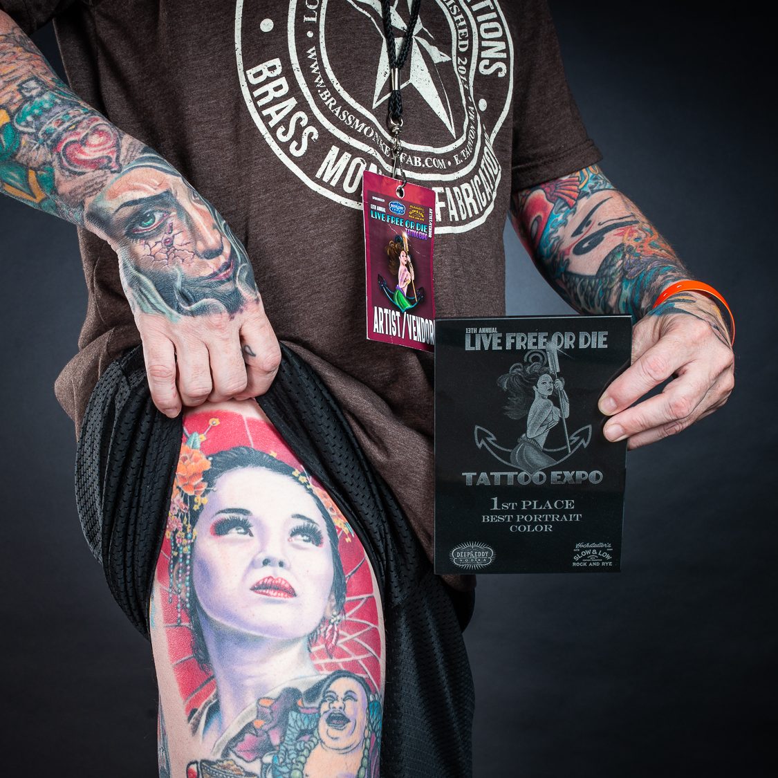 Photo of a man showing their leg tattoo and contest award
